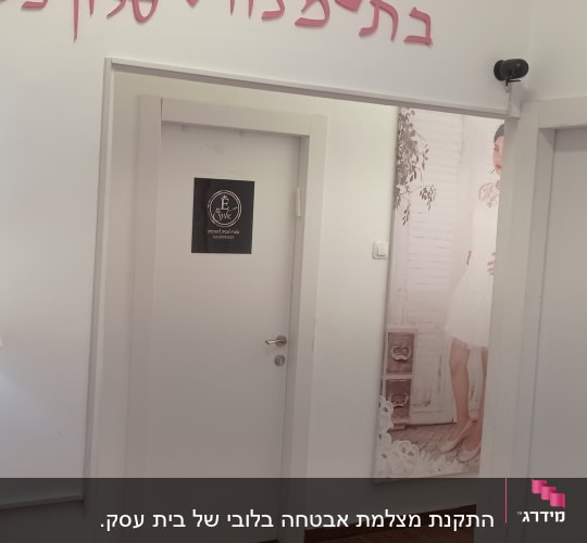 מצלמת אבטחה מותקנת בפינת החדר מעל הדלת